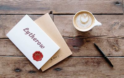 envelope coffe and pen on a table. Envelope text: Lytherow and a red seal