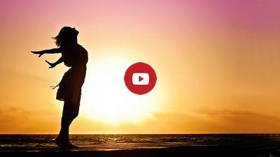 free silhouette of woman in front of sunrise seascape with Youtube play button - link to video