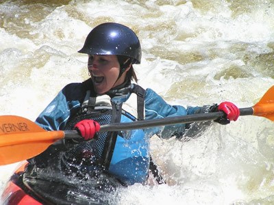 girl smiling in kayak on white water