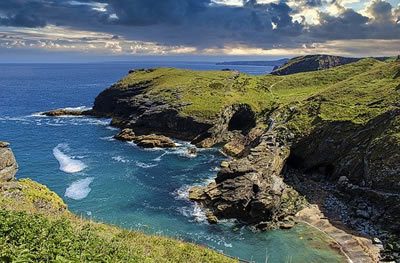 Coast of Cornwall in sunshine. Green grass and turquoise sea