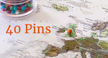 Container of map pins on a map of Europe with an orange pin in London