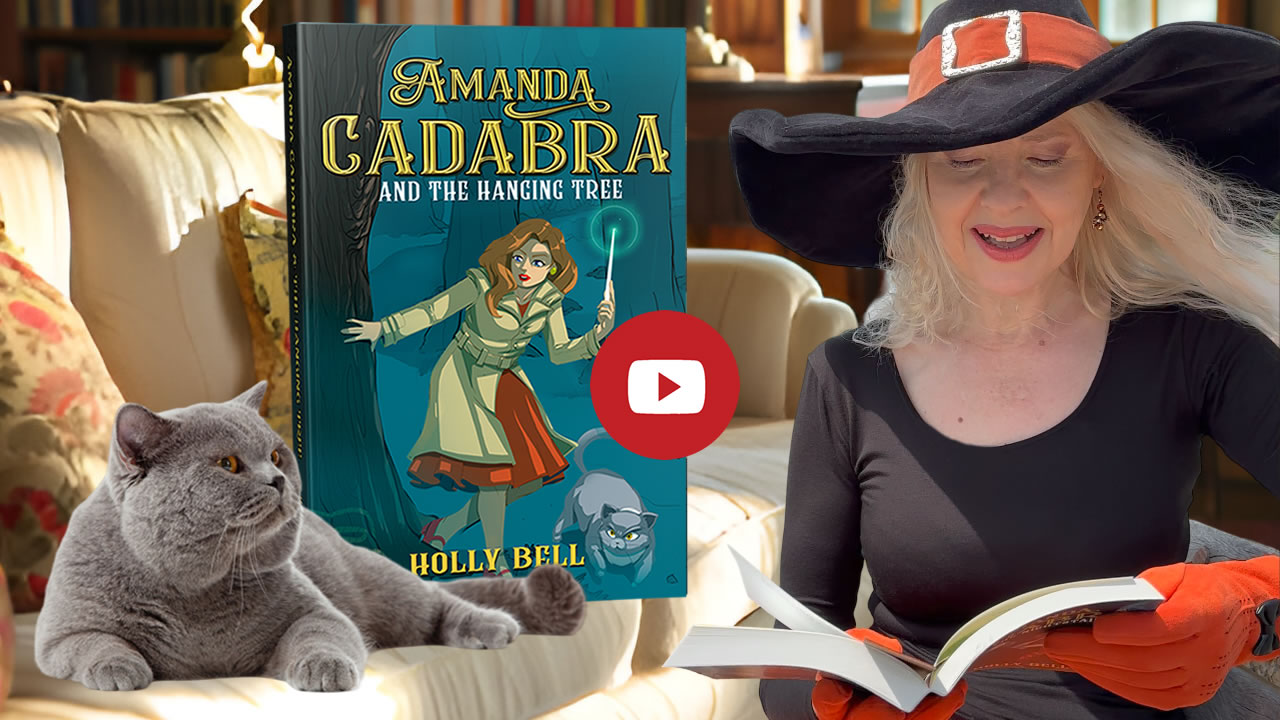 Click to go to video of Holly Bell reading Chapter 1 of Amanda Cadabra and The Hanging Tree. Image of Holly Bell in witch hat reading from Amanda Cadabra book while grey British Blue cat looks up at her grumpily from the sofa in a sunny room