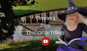 reflection in a lake of a stately home under a tree, grass in the foreground. Eerie late afternoon feeling. Text: Chapter 1 from The Grange Trilogy. Holly Bell wearing black top and witch hat with purple band, gloves and skirt, on the right reading from a book.