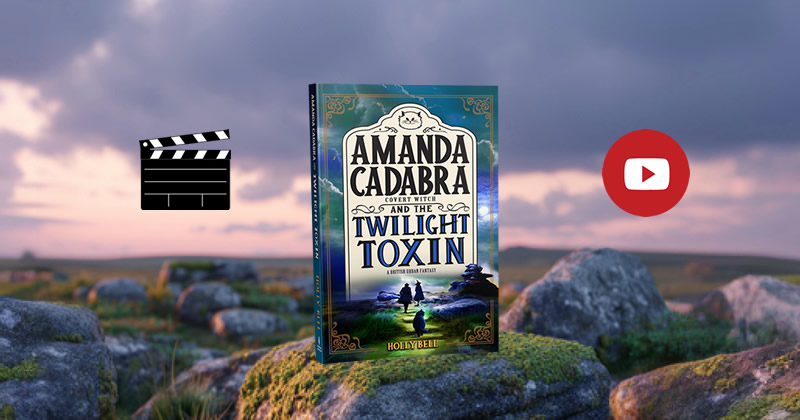 Click to go to Trailer video. Image: Book on a rock on Bodmin Moor with twilight clouds in tbe background. Cover has Amanda Cadabra and The Twilight Toxin in black font on a tall cream panel. Below and around it is the silhouette of a woman and a man a cat climbing a lime green lit path with teal bushes and blue and teal clouds above, eerie light. Bottom left is a firey reel of film, bottom right is an orchestra, left is a clapperboard and right is a play button.