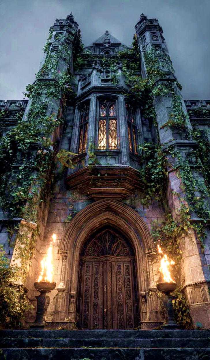 View up the façade of a gothic mansion partially covered with ivy, a light in the window above and a burning torch at either side of the entrance. Twilight sky.