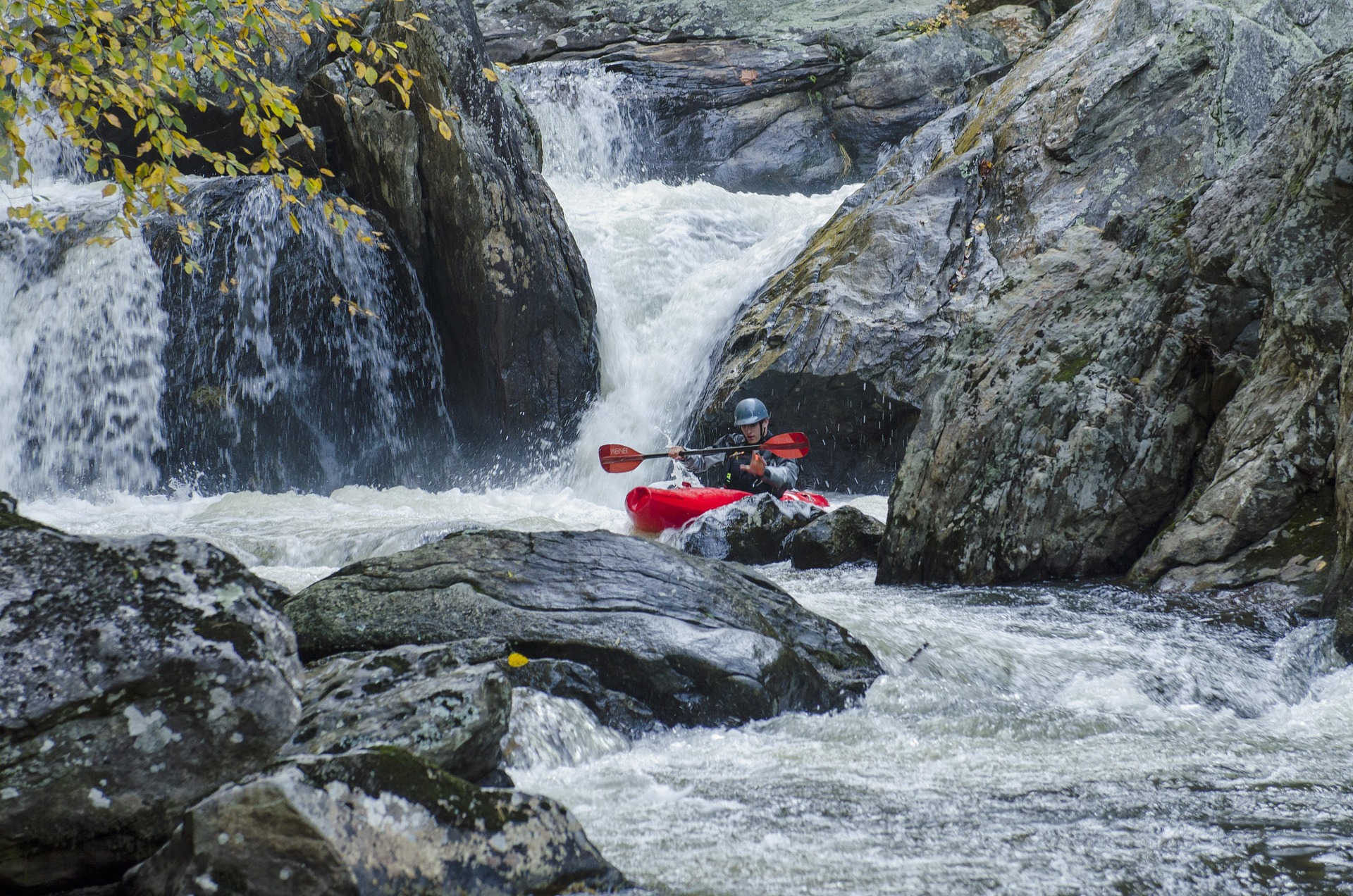 Person in red canoe on white water